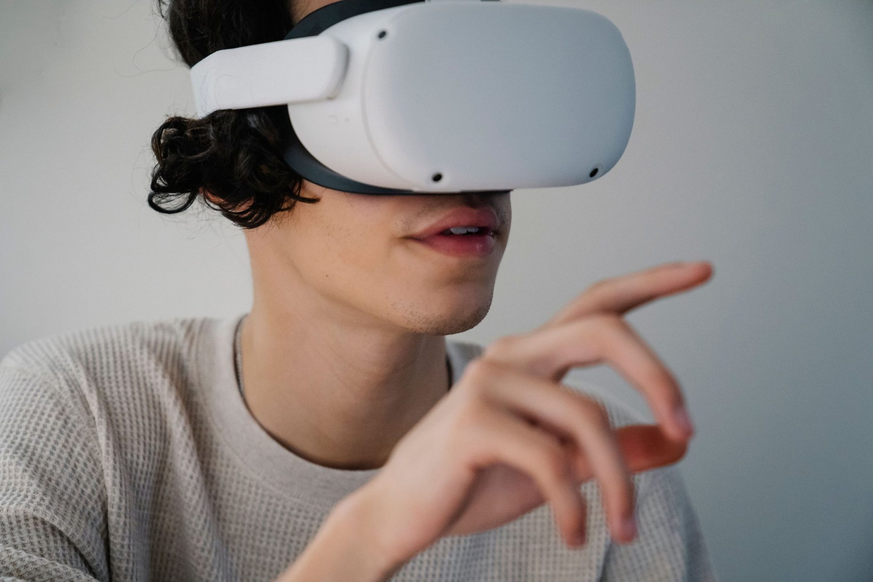 An operator wearing a VR headset demonstrating a task through teleoperation